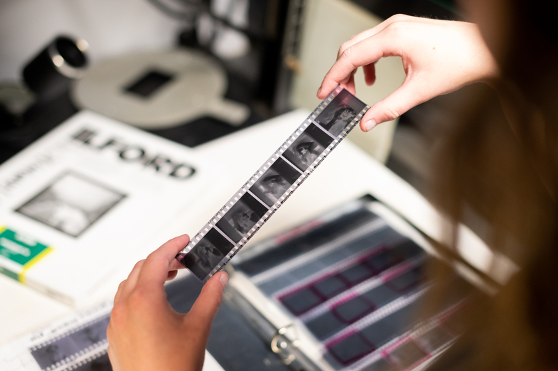 A student inspects a filmstrip.