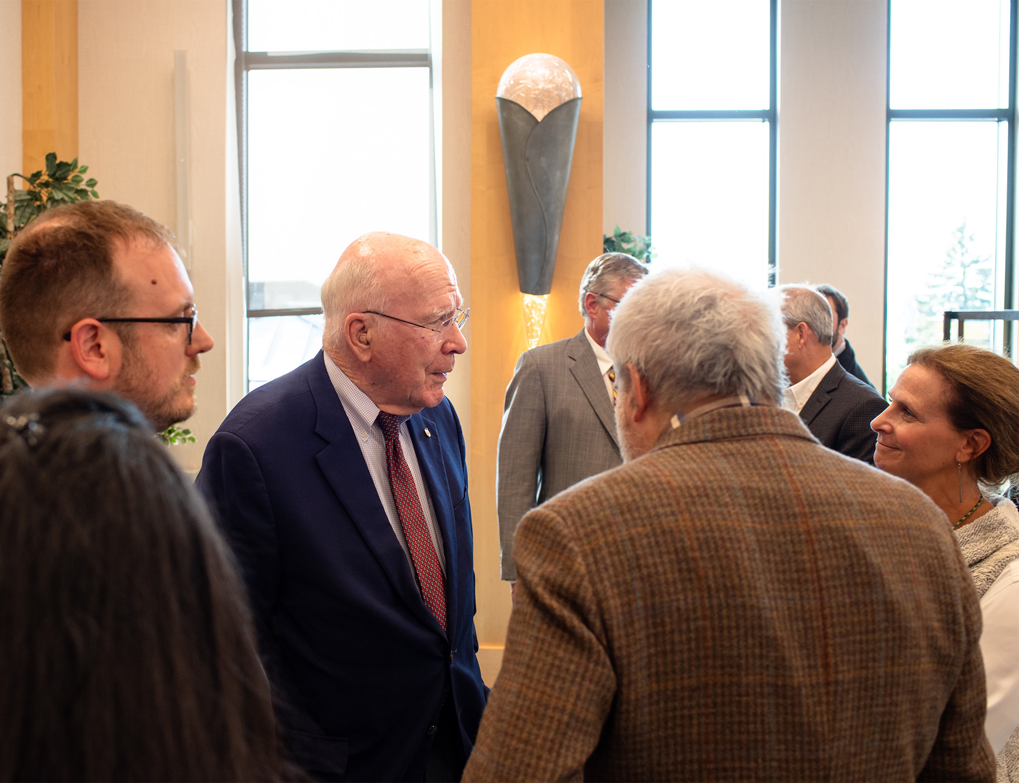 Senator Patrick Leahy speaks with Champlain College administrators and guests after a speech.