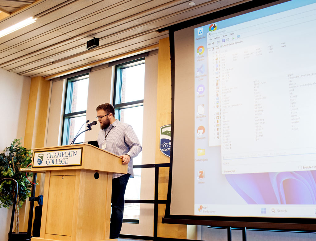 Student James Cangelosi speaks at a podium at Champlain College.