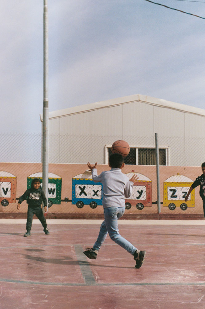 Children at Azraq Education Center play basketball